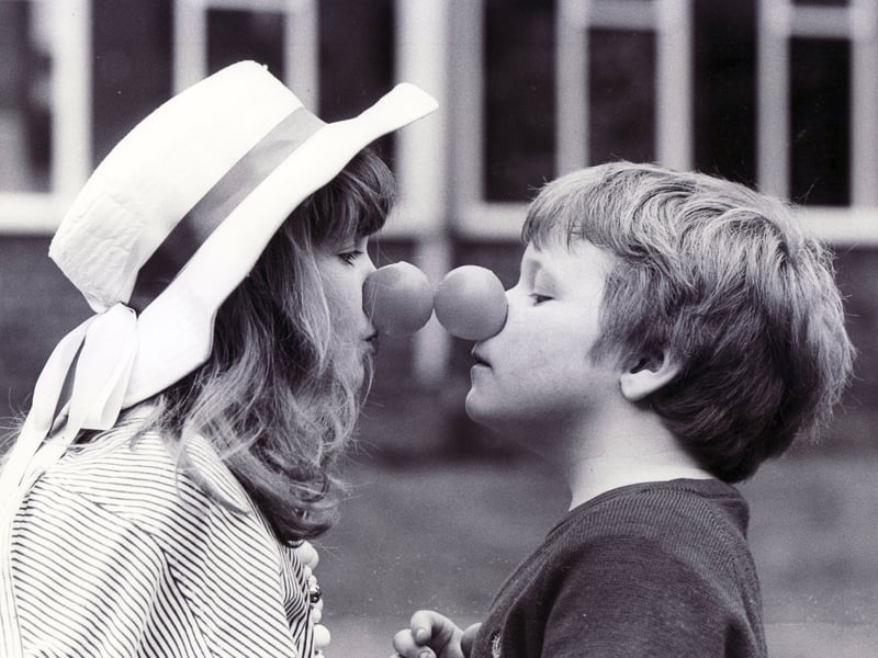 Helen Clarke (8) and Darren Hague (6) touch red noses as part of the Comic Relief celebrations at Woodthorpe School, Sheffield, in March 1989