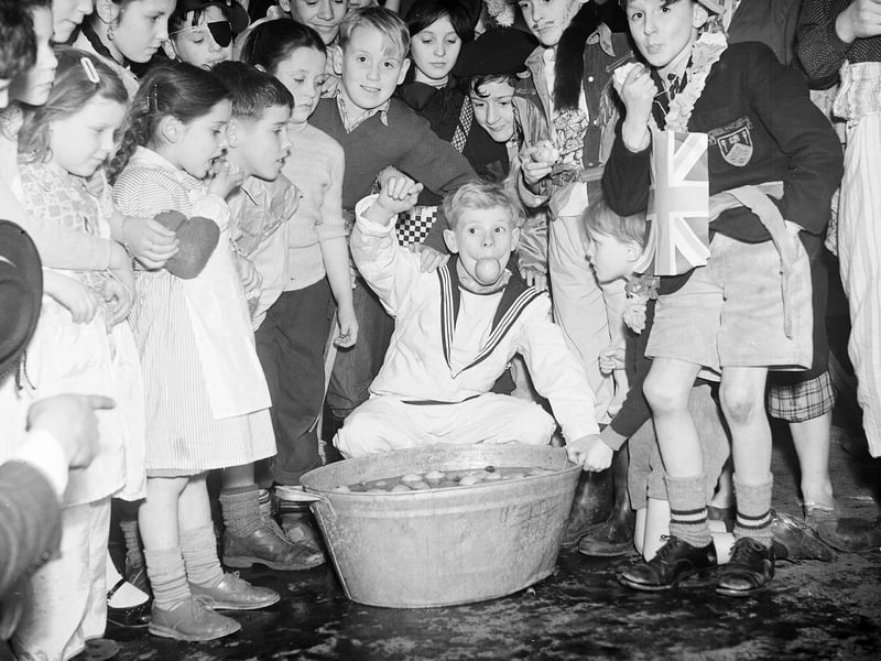 Tweedie Memorial Boys Club hold  their Halloween party at the West Port, 1956. Boys dooking for apples.