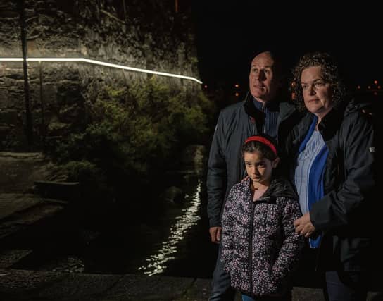 Padraig, Angela and Ava (7) Breslin viewing the light installation by Timo Aho and Pekka Niittyvirta at Spanish Arch, that marks the potential future storm surge height at the iconic location.