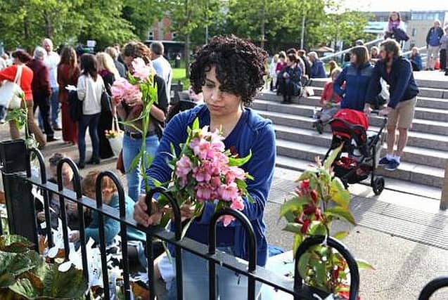 Flowers being placed on the railings in Eyre Square during the vigil to remember those who lost their lives at the mother and baby home in Tuam.