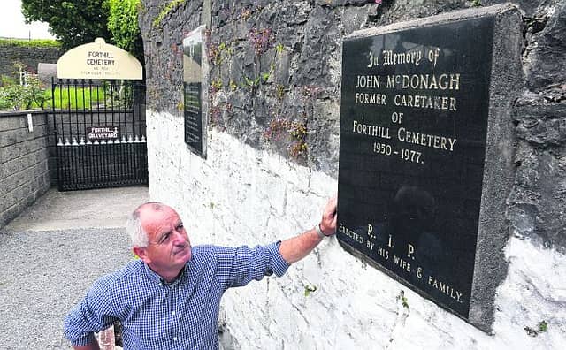 Tony McDonagh at the plaque in memory of his father, John, who preceded him as caretaker of Forthill Cemetery.