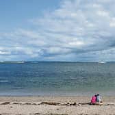 The Irish Navy's LE Samuel Beckett sails from Galway Harbour past Salthill on one of the hottest days of 2014