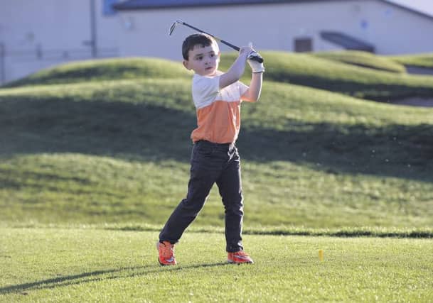 Six year-old golfer John Holland practices his golf swing at Galway Golf club.
