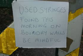 A warning sign placed at the entrance to Barna Woods by a walker.