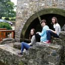 Emily, Miriam and Lilian Kennedy at the mill wheel of Finnerty's Mills, Loughrea which was restored to working order by their parents