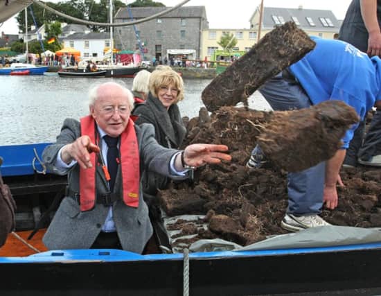 Michael D Higgins, and his wife Sabina, pictured here throwing turf off a hooker at Crinniú na mBád Festival in Kinvara during the 2011 presidential election campaign. He’s upset Galway turf cutters, who have long memories.