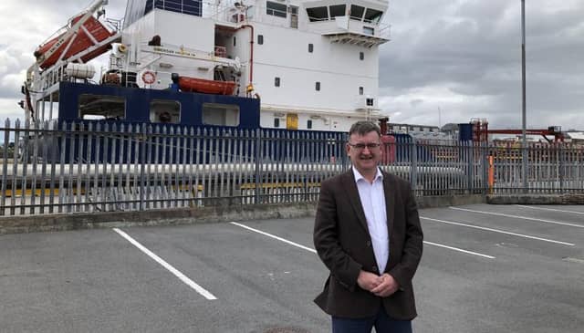 CEO of the Port of Galway Conor O'Dowd in front of a regular visitor to Galway Docks, the Corrib Fisher.