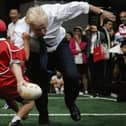 Bumbling Boris knocks over a 10-year-old boy while playing 'tough rugby' in Japan.  