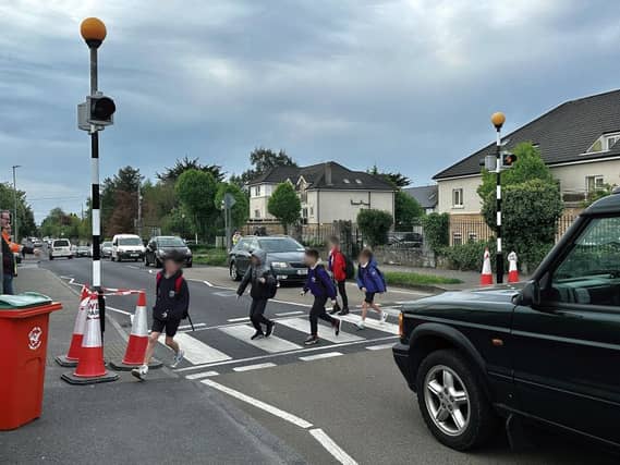 Children at the Clybaun Road crossing yesterday morning and (inset) a car was captured on camera last year driving straight through the crossing while the warden was stopping traffic.