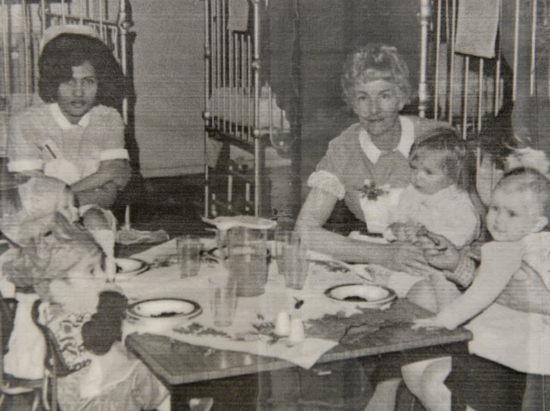 Nurses and young patients gather round a table for a special children's party on the paediatric ward at Walsall Manor Hospital during the 1960s. Framed by classic metal hospital cots, staff members sit with toddlers to help them enjoy treats, soft drinks, and party food spread across the table. These festive gatherings were organised by dedicated hospital staff to bring a bit of cheer and comfort to young youngsters spending time away from home. Were you ever a patient at Walsall Manor as a child, or do you recognise any of the friendly nursing staff here?