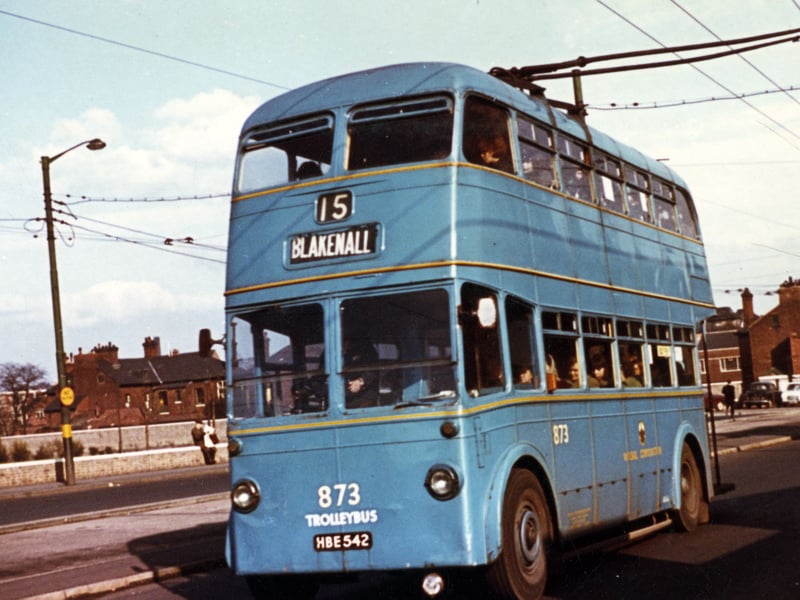 Walsall Corporation trolleybus No. 873 hums along the road on the number 15 route bound for Blakenall in 1961. Originally built for the Grimsby Cleethorpes transport system, this double-decker electric vehicle found a second lease of life serving passengers across Walsall's extensive transport network. Repainted in the municipal fleet's distinctive light blue livery, the bus offers a vibrant look at the electric street transport that kept local commuters moving before the era of all-diesel fleets took over. Do you remember riding the second-hand trolleybuses around Walsall or catching the 15 out to Blakenall?