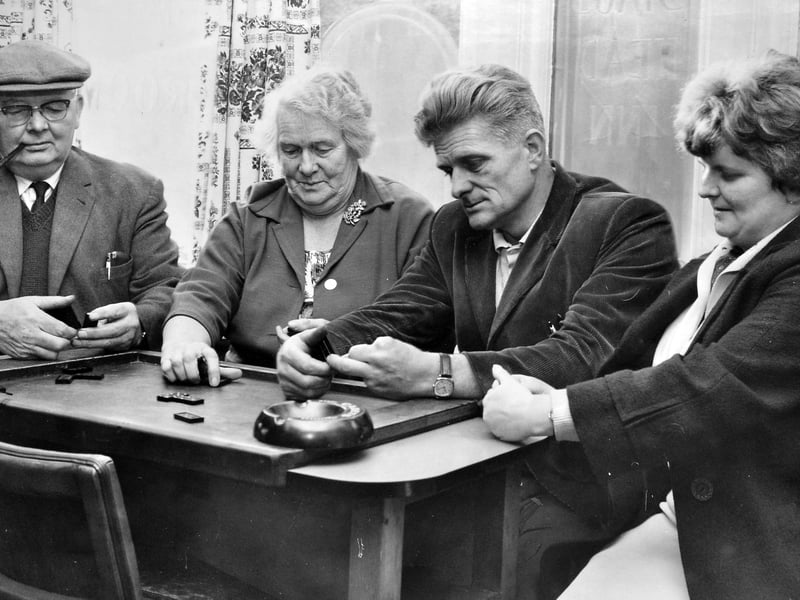 Deep in concentration, Mr Derek Heath enjoys a traditional pub game alongside his wife Daphne, his mother, and his stepfather Mr E Spragg in October 1968. Gathered around a card table complete with a piped smoker and a well-used ashtray, this cosy Market Drayton scene perfectly captures the simple, social pleasure of an autumn evening spent playing games with family at the local pub. Do you remember playing dominoes or other traditional games in Market Drayton pubs during the 1960s?
