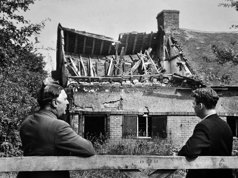 Leaning against a wooden gate etched with the year 1950, two unidentified men look on as history quietly fades away. Captured in August 1963, this photograph records the crumbling remnants of Hobbal Grange near Tong—the very haven where a defeated King Charles II stopped for supper while fleeing through Shropshire following the Battle of Worcester in 1651. Though the venerable ruined cottage remained standing through December 1966 before its eventual demolition, this moment freezes a gentle pause in time: an everyday afternoon spent gazing at the forgotten stones that once sheltered a monarch. Do you remember visiting Hobbal Grange or seeing other historic landmarks in the area before they disappeared?