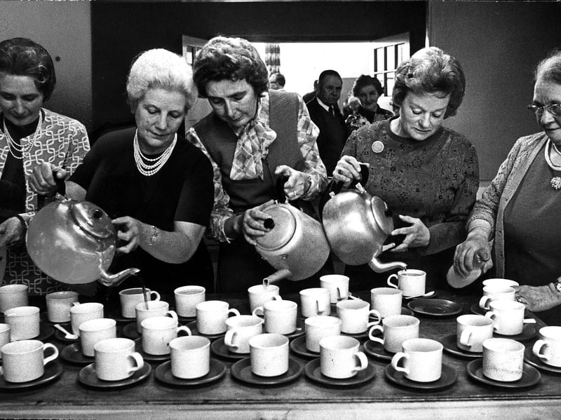 It's time for tea at the Cannock Wood and Gentleshaw Evergreen Club's Autumn Fair in October 1975. The photograph captures a familiar scene of community get-togethers, with a cuppa and a chat providing a welcome break from browsing the stalls and enjoying the event. Do you remember going to autumn fairs like this, or attending the Evergreen Club?