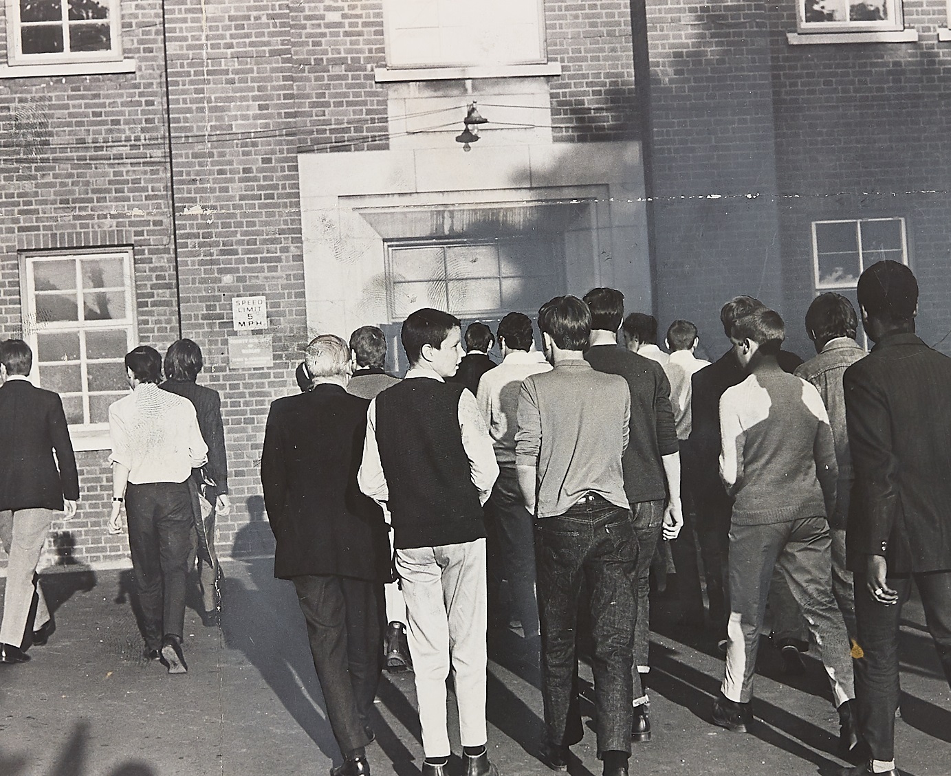 A crowd of young supporters moves toward the entrance of a building in Smethwick on June 3, 1970, ahead of a high-profile general election campaign rally held by Enoch Powell. Photographed from behind, the group local youths headed inside to hear Powell kick off his electioneering trail in the town. The moment captures the intense political atmosphere, youth subcultures, and sharp local debate that defined the run-up to the June 1970 general election across the West Midlands. Do you remember the tense political atmosphere and campaign rallies around the region during the 1970 general election? What are your memories of youth culture and political gatherings in the town back then?