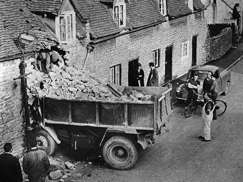 A dramatic scene in Much Wenlock in May 1967 as a lorry ended up embedded in a cottage on Sheinton Street. Curious onlookers gathered to see the unusual sight, watching with folded arms as the damage was assessed. Moments like this would have quickly become the talk of the town - do you remember hearing about this incident, or the cottage and street as they looked back then?