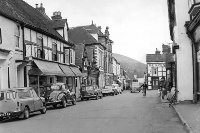 A peaceful scene from Church Stretton High Street in May 1967, when the pace of life seemed a little slower. Parked cars line the street, while a child on a bicycle adds a lovely everyday touch to this snapshot of village life. Do you remember cycling around the town as a child, or the familiar shops and faces that made up the High Street back then?