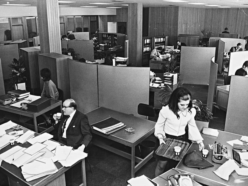 Office workers settle into a state-of-the-art workspace inside St John's House in Wolverhampton on April 10, 1970. Following Collis Radio’s move into the stylish suite of offices late the previous year, the company introduced a contemporary open-plan design featuring office landscaping, potted plants, and curved dividing screens. The modern setup was designed to give staff maximum comfort and privacy without "boxing up" employees into traditional, isolated offices - complete with tea trays, rotary telephones, and stacks of paperwork. Do you remember working in an open-plan office like this during the 1970s? How did the arrival of office "landscaping," room dividers, and morning tea service change the daily routine at your workplace?