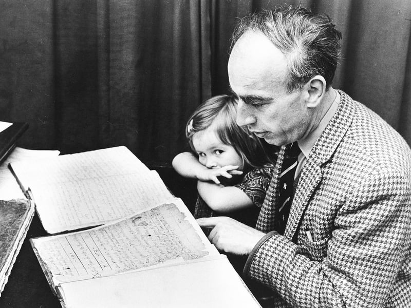 Leaning over delicate, handwritten parish ledgers dating back to 1735, the Rev Robert Cheadle explores historical documents alongside his three-year-old daughter, Katie, at Bloxwich Parish Church on September 11, 1970. After sifting through the church's ancient archives, the vicar remarked that students of literature and local history could easily find enough intrigue, romance, and drama in the parish records to inspire a first-class novel. The tender photo captures both a quiet father-daughter moment and a passionate appreciation for preserving local heritage. Do you remember the Rev Bob Cheadle or visits to Bloxwich Parish Church back in the 1970s? Have you ever researched your family tree or local history using historic church registers?