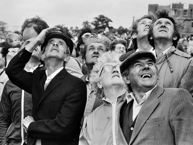 Eager spectators scan the clouds above RAF Shawbury during the air show and Round Table summer fair on Saturday, July 20, 1985. Thrilled crowds were treated to a jaw-dropping performance by the world-famous Red Arrows, though gusty conditions unfortunately grounded the iconic Battle of Britain Memorial Flight. Were you among the thousands looking up into the Shropshire sky on that breezy July afternoon?