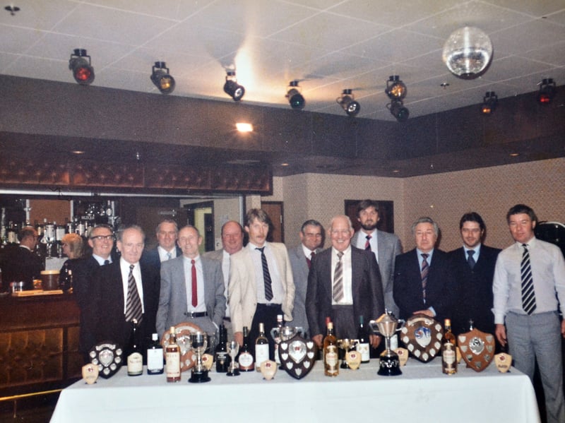 Workers from Ketley's Glynwed Foundry gather behind an impressive haul of trophies and shields during an in-house domino presentation evening on October 26, 1985. Pictured enjoying the celebration are Brian, Fred Hunter, Maurice, Ron Greenfield, Bobby Austin, Chris, Andy Corbett, Les Vicks, John Moseley, John, Donald Dabbs, and Kevin Mahon. Do you recognise any of these local foundry workers or remember where this glamorous award night took place in 1985?