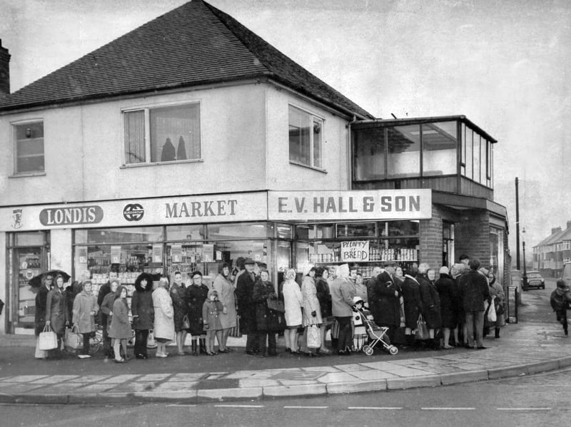 Wrapped in heavy winter coats and headscarves, nearly 100 locals queue patiently outside the E V Hall & Son Londis market in West Bromwich in March 1974. Amid bitter sleet and snow—and with a drivers’ strike sparking a severe bread crisis across the West Midlands—shopkeeper John Hall came to the rescue after secretly arranging a delivery of 900 loaves from a village bakery near Gloucester. Word travelled fast through neighbourhood streets, prompting a rush of shoppers eager to spot the handwritten "Plenty of Bread" sign in the corner window. Did you brave the chilly queues outside Londis on that freezing morning, or remember how your family tracked down bread during the 1974 deliveries strike?