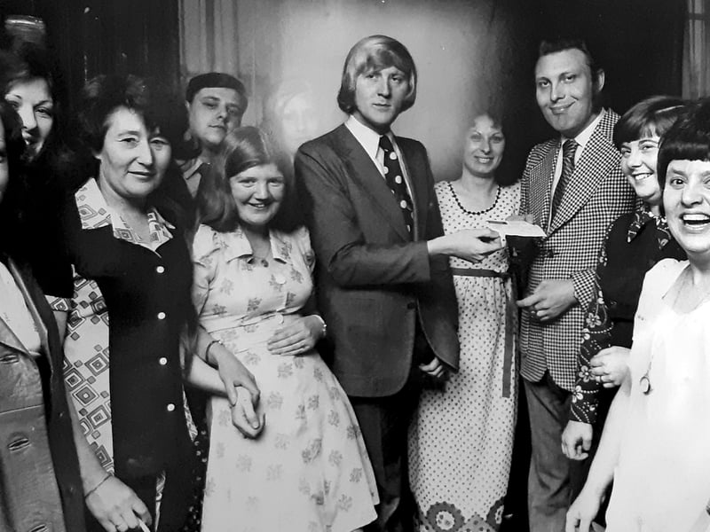 Sporting his trademark mid-seventies sweep of blonde hair and a polka-dot tie, ATV Today roving reporter Chris Tarrant hands over a cheque during a charity presentation at the George & Crown pub in Willenhall in May 1974. Before rising to national fame on shows like Tiswas and Who Wants to Be a Millionaire?, Tarrant was a regular, much-loved face across the Midlands on local television, frequently out and about meeting pub regulars, charity organisers, and community stalwarts across the Black Country. Do you recognise yourself or any familiar local faces gathered around Chris Tarrant at the George & Crown, or do you remember him dropping into Willenhall back in 1974?
