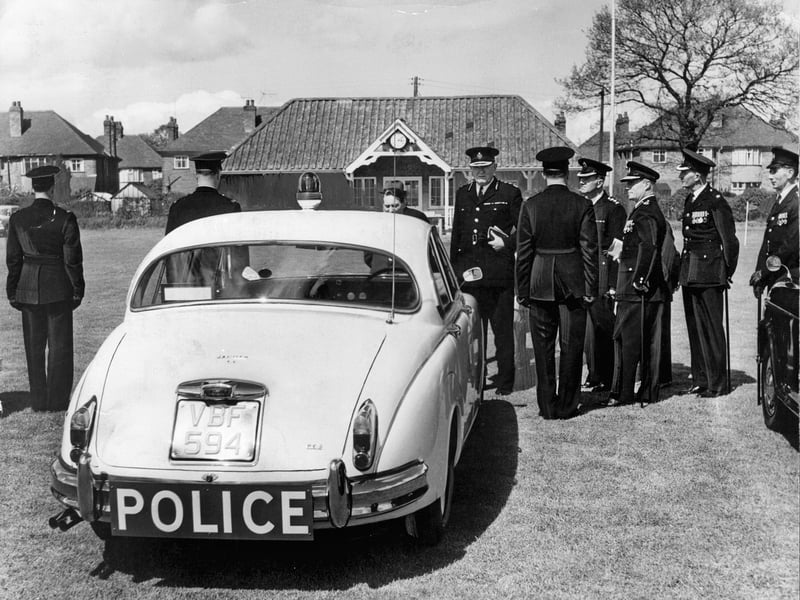 HM Inspector of Constabulary Sir Charles Martin chats with the driver of a brand-new Jaguar patrol car at county police headquarters in Stafford in May 1962. Gathered alongside senior officers on the grounds, Sir Charles inspects the high-performance vehicles drafted in specifically for patrols on the newly developing M6. Equipped with roof lights and bold rear signage, these powerful Jaguars brought serious style and speed to motorway enforcement as Britain entered the modern highway era. Do you remember seeing these iconic Jaguar police cars cruising along the M6 during the early 1960s?