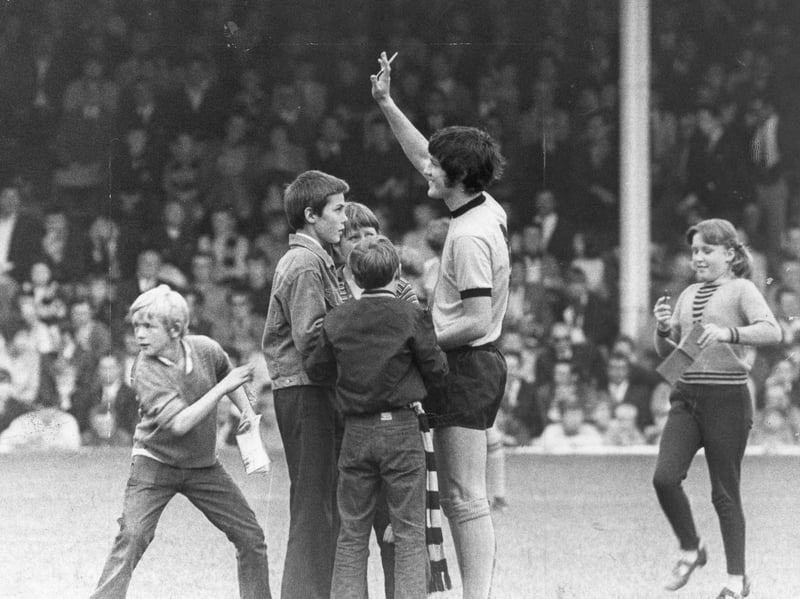 Maverick forward Peter Knowles raises his hand to acknowledge the adoring Molineux crowd in September 1969 before kicking off his final match against Nottingham Forest. Surrounded by young, starstruck supporters on the pitch, the charismatic 24-year-old was at the height of his career when he made the extraordinary decision to step away from professional football to become a Jehovah's Witness. His sudden departure left fans stunned, making this poignant moment one of the most famous and talked-about chapters in the history of Wolverhampton Wanderers. Were you in the crowd at Molineux to witness Peter Knowles play his final game for Wolverhampton Wanderers?