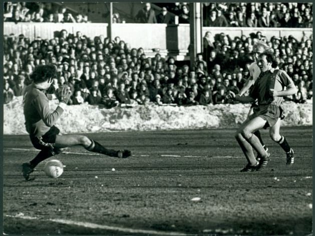 A packed, roaring crowd looks on as winger Paul Maguire slots home past England goalkeeper Joe Corrigan on the frost-hardened Gay Meadow turf, sparking Shrewsbury Town's unforgettable two-nil FA Cup giant-killing of Manchester City on January 27, 1979. Where were you standing when the ball hit the back of the net against City? Can you still feel the incredible roar that went through Gay Meadow that afternoon?
