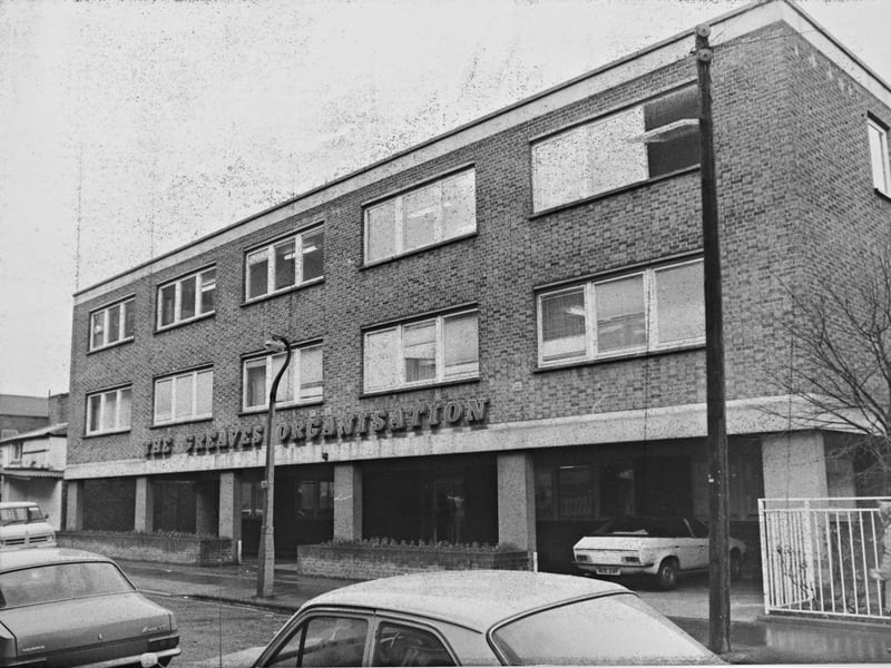 The purpose-built office premises of The Greaves Organisation stand along the street in West Bromwich in December 1976. With modern vehicles parked outside and pedestrians braving the winter chill past the brick facade and raised ground-floor entrance, the site was a familiar commercial landmark for the well-known regional construction and property development group. Did you ever work for The Greaves Organisation or do business at their West Bromwich offices back in the winter of 1976?