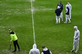 Shelbourne players look on as Galway United volunteers fork the pitch in a bid to get the game the go-ahead.