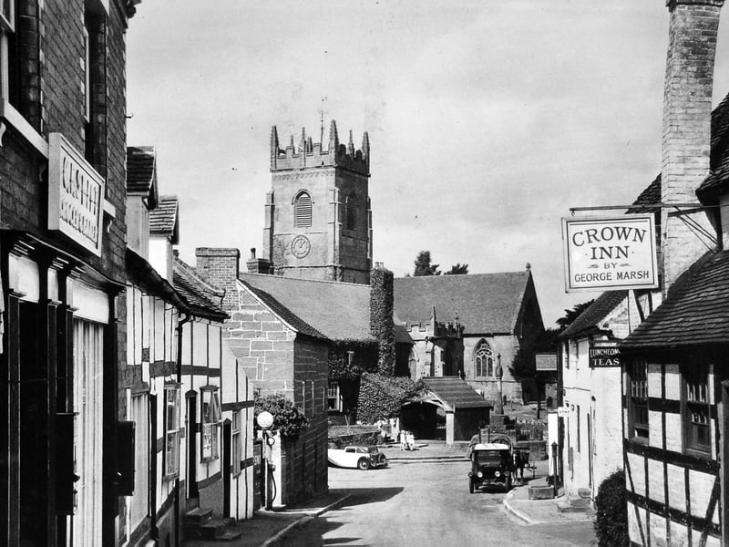 A nostalgic 1930s view of Claverley village, showing the Crown Inn on the right—its chimney stack famously leaning—and Claverley church in the distance. Captured in a postcard scene, the image features the Crown Inn (kept by George Marsh) and a classic rural village view.