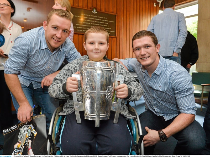 1 October 2012; Nathan O'Hagan-Doyle, aged 10, from Bray, Co. Wicklow, holds the Liam MacCarthy Cup alongside Kilkenny's Richie Hogan, left, and Paul Murphy during a visit to Our Lady's Hospital for Sick Children, Crumlin, Dublin
