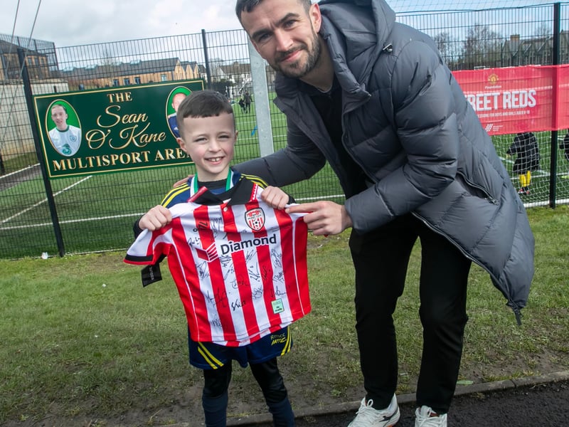 Derry City star Michael Duffy presents a signed Derry City shirt.