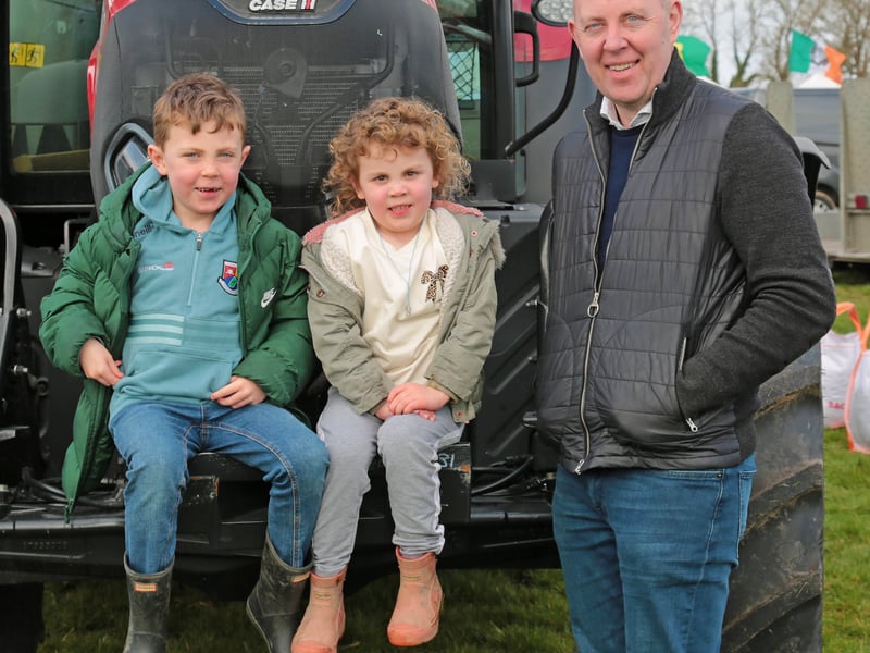 Caption: Joe, Ruby and Cllr Paul Ross relaxing alongside one of the many tractors on display 