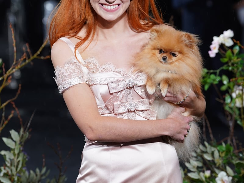 Her accessory was unorthodox for the red carpet, as she carried a small Pomeranian under her arm.