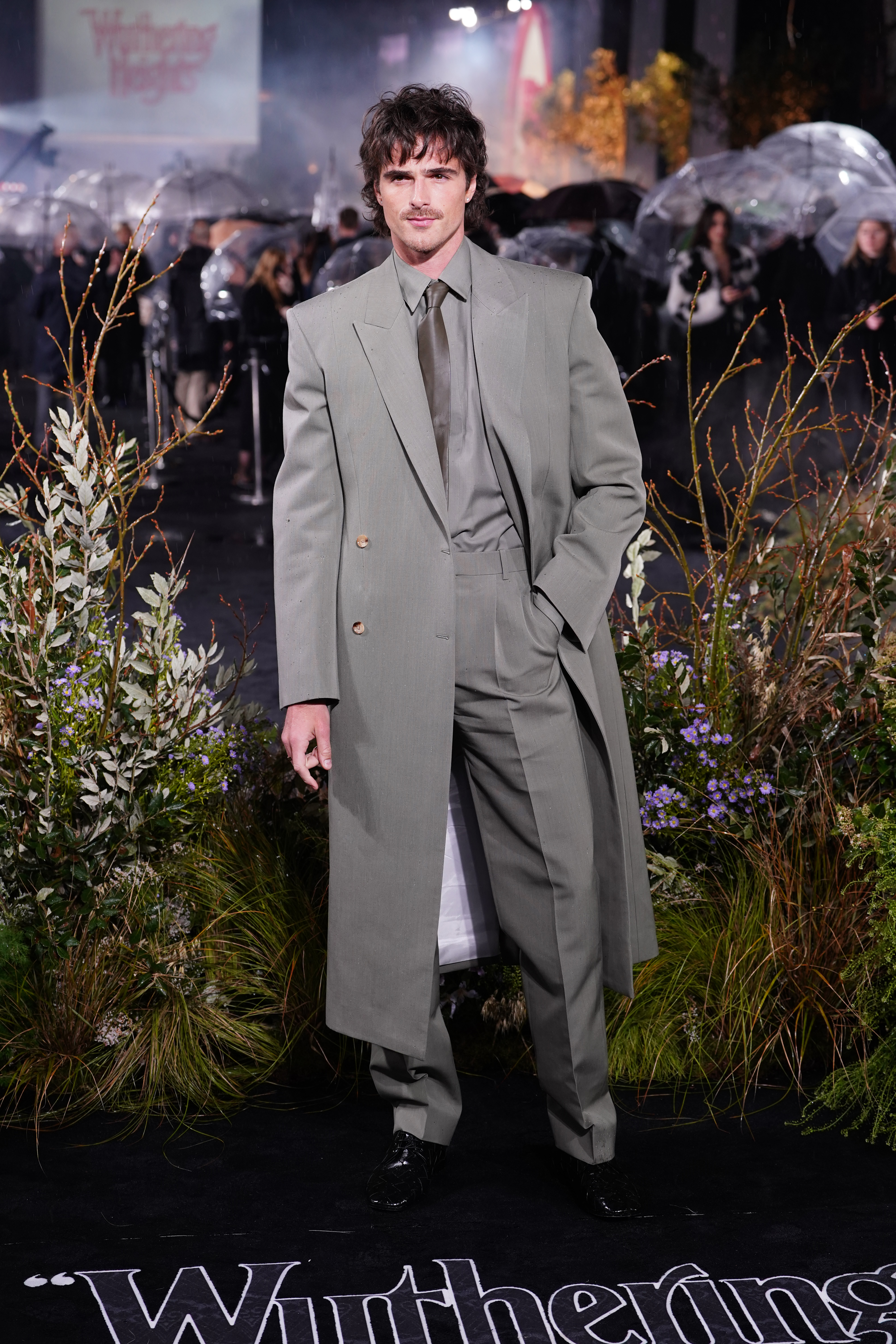Jacob Elordi, 28, who plays Heathcliff in the film, stepped out in a monochromatic, slate grey suit with a leather tie and a double breasted overcoat.