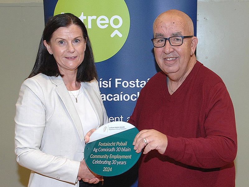 Below: Noeleen Mallon of the DSP presenting a plaque to Tubby Corrway of the Redeemer Community group