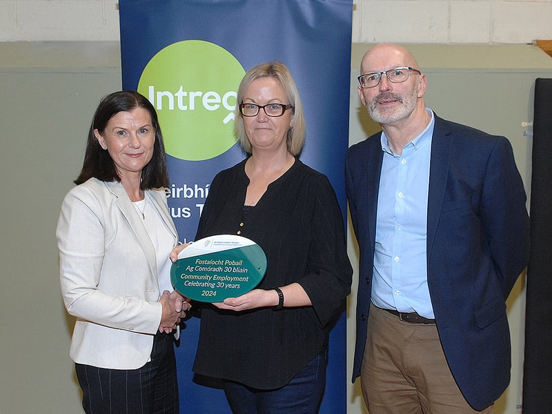 Below: Noeleen Mallon and Paul McArdle of the DSP presenting Jennifer Lawrence of St Josephs Community Group with her plaque