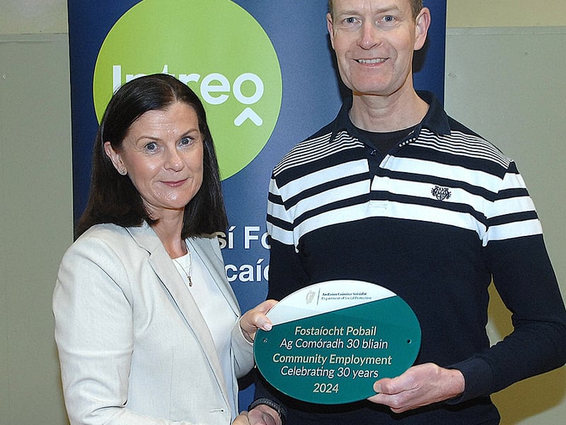 Below: Paul McGlinn of the Simon Community and Women's Aid group receiving a plaque from Noeleen Mallon of the DSP scheme