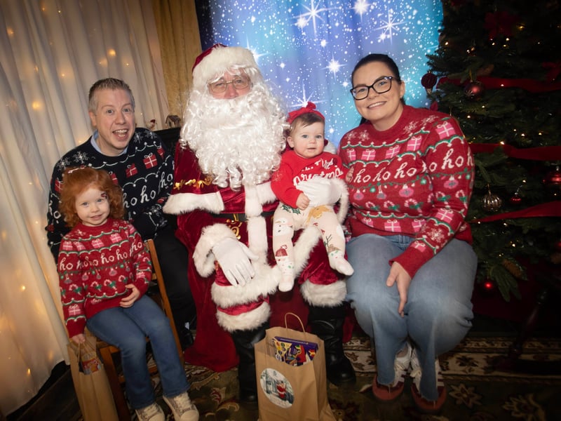 One of the many families getting a photo and collecting a present from Santa on Saturday at Derry Credit Union.