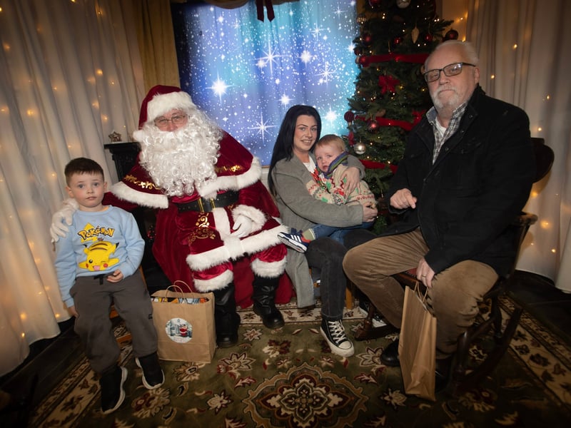 One of the many families getting a photo and collecting a present from Santa on Saturday at Derry Credit Union.