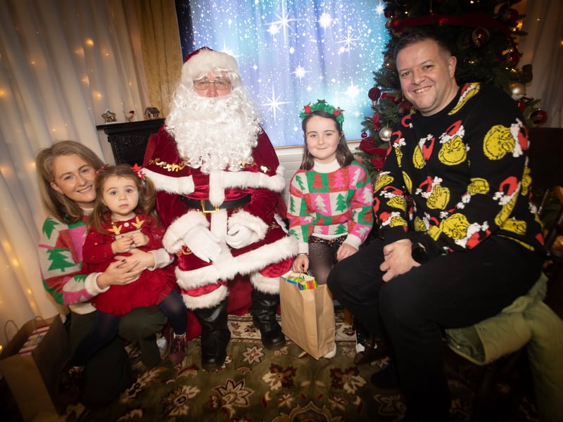 One of the many families getting a photo and collecting a present from Santa on Saturday at Derry Credit Union.