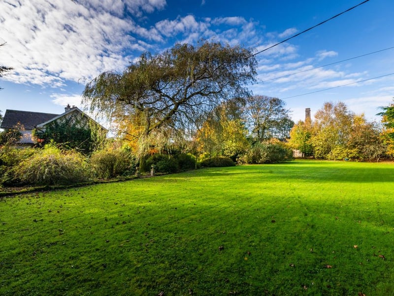Like something out of The Secret Garden, a stunning period property built near Mountmellick by a historical figure has hit the market for €595,000. Set on 7.7 acres, The 200 year old Mill House promises stunning scenery, a gorgeous apple orchard, wildflower meadows and the ruins of the famous Mountmellick Mill. The Mill House, located in the townland of Drinagh, also known as New Mills, dates back to the early 1800s and carries a remarkable industrial heritage. The earliest records of New Mills appear in 1818, when Joseph Nevitt, noted in Quaker burial archives, resided here and later entered into partnership with John Millner. Together they established a thriving woollen manufacturing business, later expanding into a corn and saw mill. By the mid-1800s, the Millners’ enterprise was well known throughout the region, employing many locals and contributing to the area’s economic development. Elements of the original mill structures still remain on the property today, a lasting testament to the craftsmanship and industrious spirit of that era. Set on approximately 7.7 acres, The Mill House extends to c.214 m² and is surrounded by lavish, mature gardens, an orchard, wild meadow, and beautiful old trees, creating a sense of peace and privacy rarely found. The land is divided into four well-fenced paddocks, making it perfect for livestock or equestrian use thanks to its excellent security and layout. There is also a floodlit arena ideal for night-time riding out, offering superb convenience for horse owners. The current owners have lovingly preserved many of the original features, including stonework, arched brick detailing, and solid timber beams, showcasing the charm and authenticity of this extraordinary home. The accommodation consists of an entrance hall, kitchen cum dining room, living room, sitting room, home office, boot room, laundry, five bedrooms, main bathroom, and guest bathroom. Every room is filled with character, from exposed stone walls to original craftsmanship that reflects the history