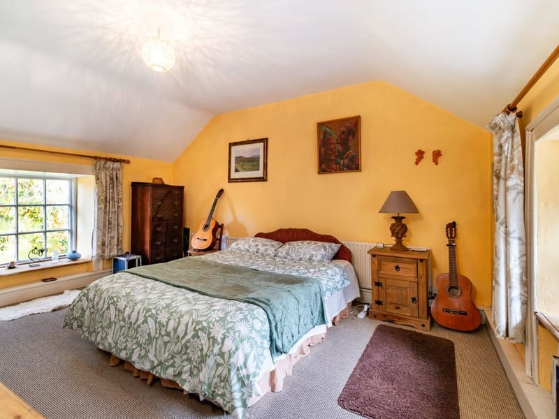 Like something out of The Secret Garden, a stunning period property built near Mountmellick by a historical figure has hit the market for €595,000. Set on 7.7 acres, The 200 year old Mill House promises stunning scenery, a gorgeous apple orchard, wildflower meadows and the ruins of the famous Mountmellick Mill. The Mill House, located in the townland of Drinagh, also known as New Mills, dates back to the early 1800s and carries a remarkable industrial heritage. The earliest records of New Mills appear in 1818, when Joseph Nevitt, noted in Quaker burial archives, resided here and later entered into partnership with John Millner. Together they established a thriving woollen manufacturing business, later expanding into a corn and saw mill. By the mid-1800s, the Millners’ enterprise was well known throughout the region, employing many locals and contributing to the area’s economic development. Elements of the original mill structures still remain on the property today, a lasting testament to the craftsmanship and industrious spirit of that era. Set on approximately 7.7 acres, The Mill House extends to c.214 m² and is surrounded by lavish, mature gardens, an orchard, wild meadow, and beautiful old trees, creating a sense of peace and privacy rarely found. The land is divided into four well-fenced paddocks, making it perfect for livestock or equestrian use thanks to its excellent security and layout. There is also a floodlit arena ideal for night-time riding out, offering superb convenience for horse owners. The current owners have lovingly preserved many of the original features, including stonework, arched brick detailing, and solid timber beams, showcasing the charm and authenticity of this extraordinary home. The accommodation consists of an entrance hall, kitchen cum dining room, living room, sitting room, home office, boot room, laundry, five bedrooms, main bathroom, and guest bathroom. Every room is filled with character, from exposed stone walls to original craftsmanship that reflects the history