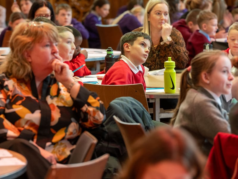Mayor of Derry City and Strabane District Council, Councillor Ruairí McHugh pictured with over 200 Primary School pupils in the Guildhall where they discovered a range of interesting facts about the Mayor’s role as First Citizen of the City and District, as part of Local Democracy Week.