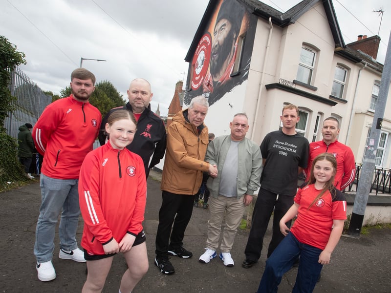 The late Jon 'Ugg' Clifford's family members Frankie Fleming and Jim Clifford pictured with Liam Bradley, owner of the Laburnum Terrace house that Jon's mural is painted on. Included is Liam's son Jack who played for Tristar, along with club officials and players. (Photos: Jim McCafferty Photography)
