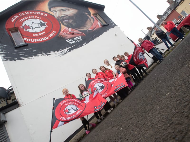 A section of the younger Tristar players pay homage to the club founder Jon 'Ugg' Clifford during a new mural unveiling in his honour overlooking Bull Park on Saturday.