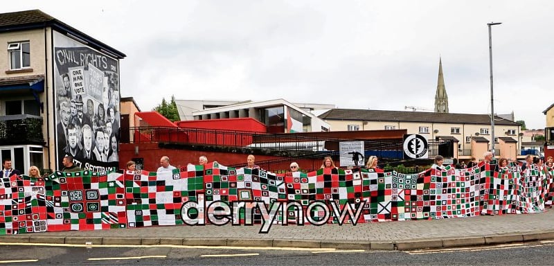 Mayor Ruairí McHugh with Tony Doherty, Bloody Sunday Trust, Ciara Ferguson, MLA, Colr. Emma McGlinley, Colr. Christopher Jackson and those who created the Granny Squares for Gaza quilt which arrived at the Museum of Free Derry.